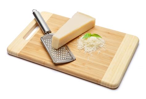 Un Trozo De Parmesano Y Queso Rallado Sobre Tabla Para Cortar Foto