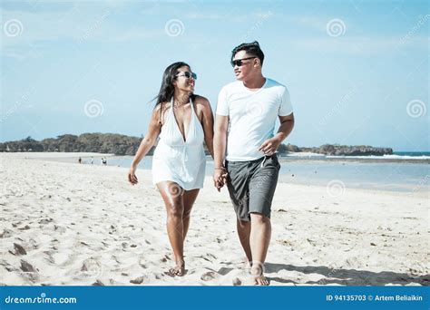 Asian Couple Walking On The Beach Of Tropical Bali Island Indonesia