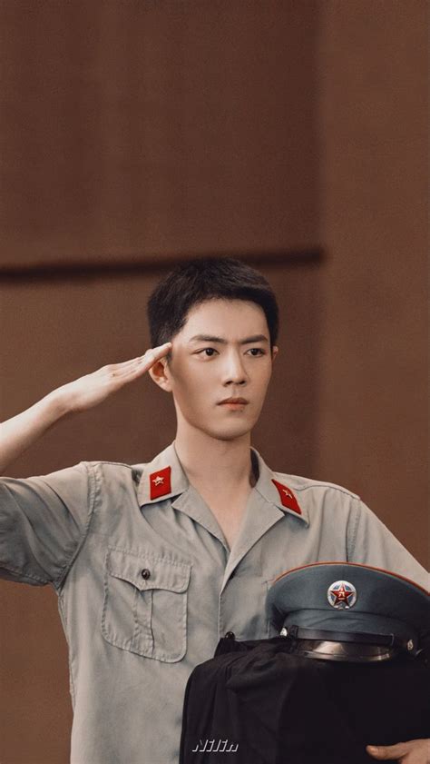 A Man In Uniform Saluting With His Hand On His Head While Standing Next