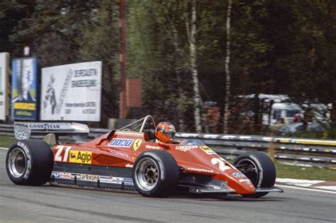 A Man Driving A Racing Car On A Race Track