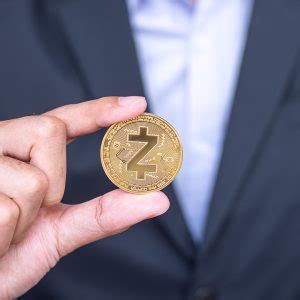 Mão de empresário segurando a moeda de criptomoeda dourada ZCASH ZEC