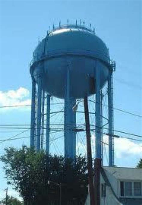 A Large Blue Water Tower Sitting On The Side Of A Road