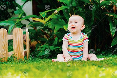 lovely baby sitting   grass laughing loudly stock image image
