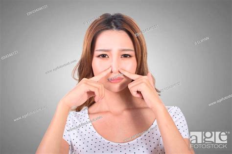 Portrait Of A Young Woman Holding Her Nose Because Of A Bad Smell