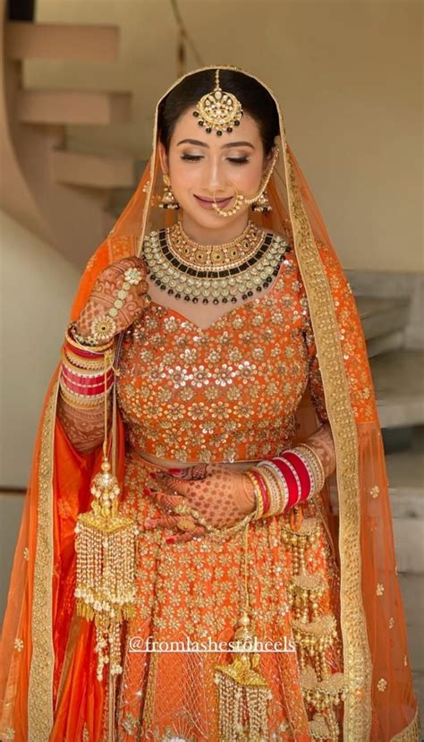 A Woman In An Orange And Gold Bridal Outfit