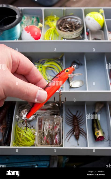 A fisherman selects the right lure from his tackle box that he is going ...