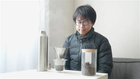 Japanese Man In His S Pours Hot Water Into Coffee While Reading A Book Stock Video Video Of