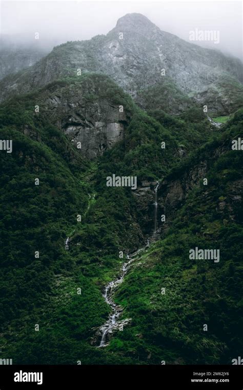 Moody Landscape With A Waterfall Falling On The Naeroyfjord In