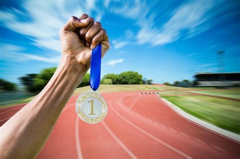 Imagen Compuesta De Mano Sujetando Una Medalla De Plata Sobre Fondo