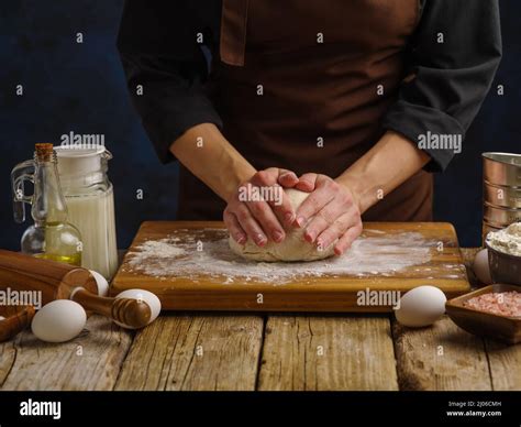 Un Chef Profesional Amasa La Masa Sobre Una Tabla De Corte De Madera