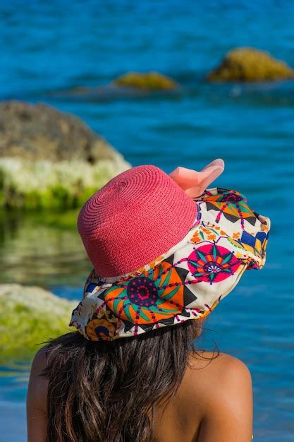 Premium Photo Rear View Of Woman In Colorful Hat At Beach