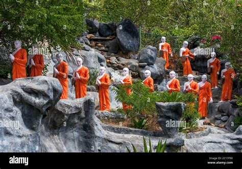 A Line Of Buddhist Monk Statues Approaching The The Golden Temple At