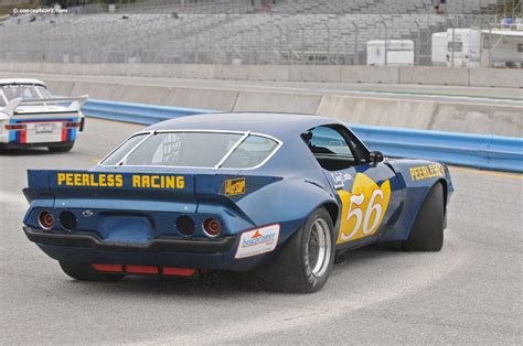 Two Race Cars Racing On A Track With The Number Behind Them And One