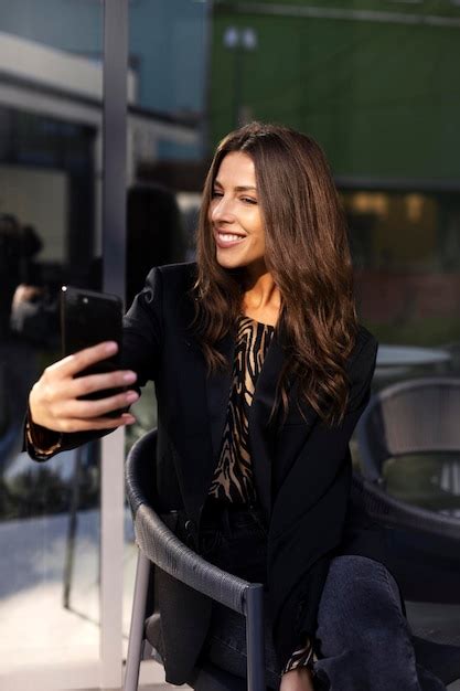 Premium Photo | Smiling beautiful girl holding a mobile phone in her ...