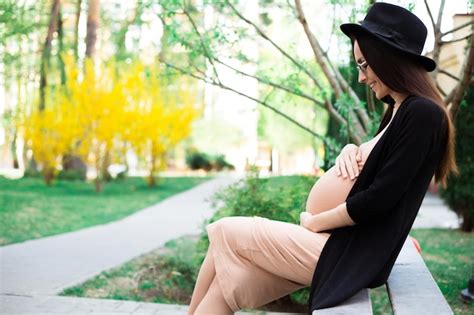 Premium Photo Stylish Pregnant In Hat And Sunglasses Sitting On A