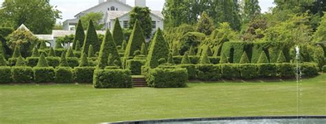 a large house surrounded by lush green trees and bushes in front of a ...