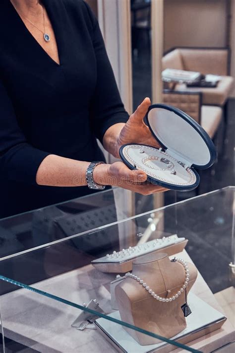 El Ayudante De Tienda Elegante De Joyer A Est Mostrando El Collar