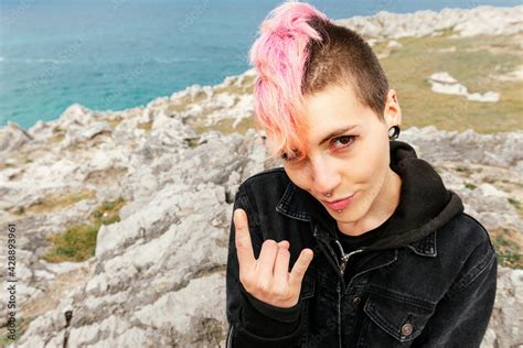 Vertical Portrait Of Sitting Punk Woman Sticking Her Tongue Out And