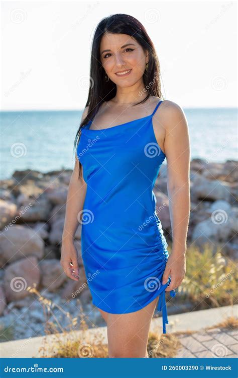 Beautiful Caucasian Girl In Short Blue Dress Posing Outside With Lake