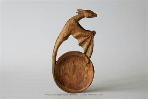 A Wooden Sculpture Of A Dragon Sitting On Top Of A Round Object In The