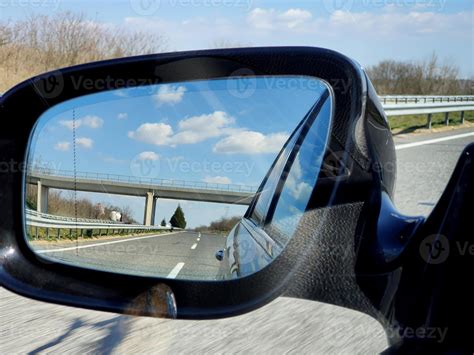 paisagem e reflexão da estrada no espelho retrovisor do carro preto