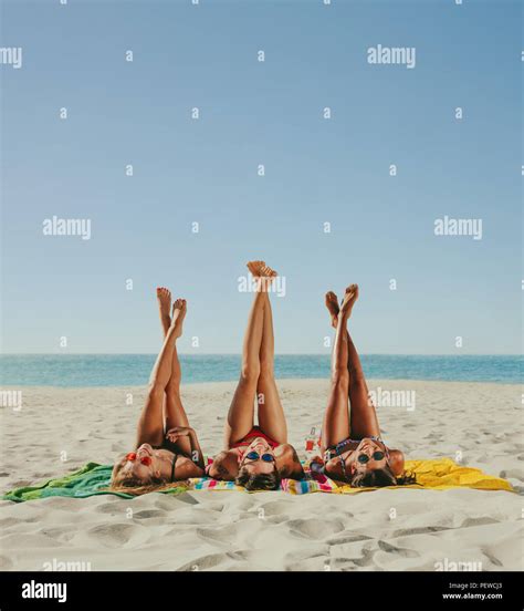 Tres Amigas Tumbado En La Playa Tomando El Sol En Bikini Posando Para