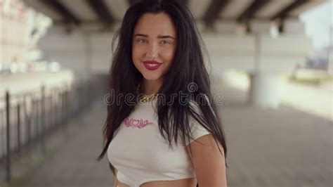 Slow Motion A Brunette Girl With Long Hair Straightens Hair With Hands And Looking At The