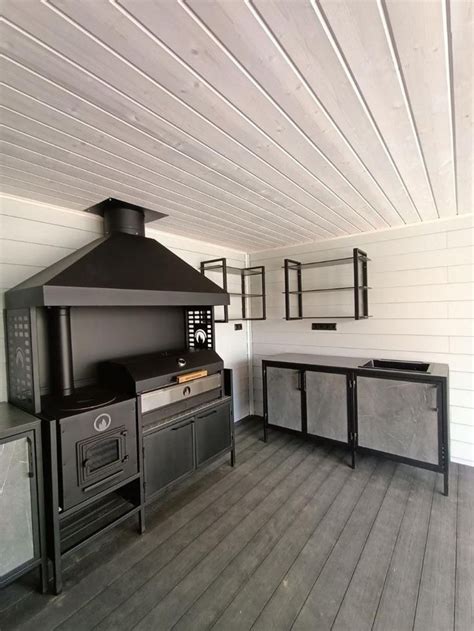 an outdoor kitchen with wood floors and white walls