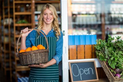 Premium Photo Smiling Female Staff Holding Basket Of Fruit In Supermarket