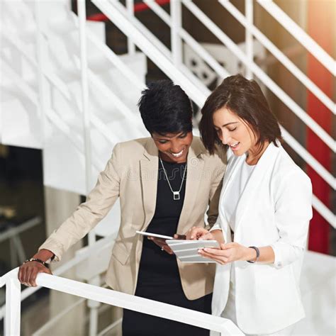 Dedicated Businesswomen Two Businesswomen Using A Digital Tablet In An