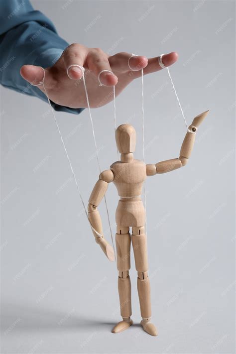 Premium Photo | Woman pulling strings of puppet on light grey
