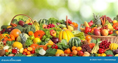 Assortment Of Fresh Organic Vegetables And Fruits On Blurred Green