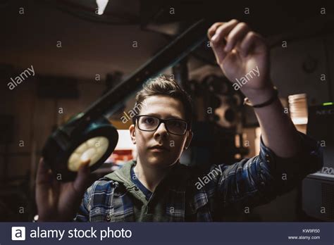 Serious Caucasian Tween Boy Projectionist Checking Film In Movie