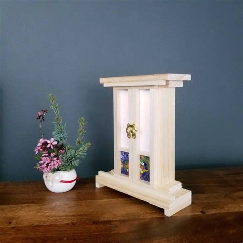 A Vase With Flowers Sitting On Top Of A Table Next To A Small Wooden