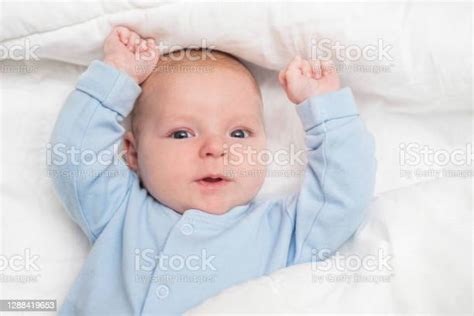 Portrait Of A Cute Baby Lying Down On A Bed Baby On White Cloth Lying