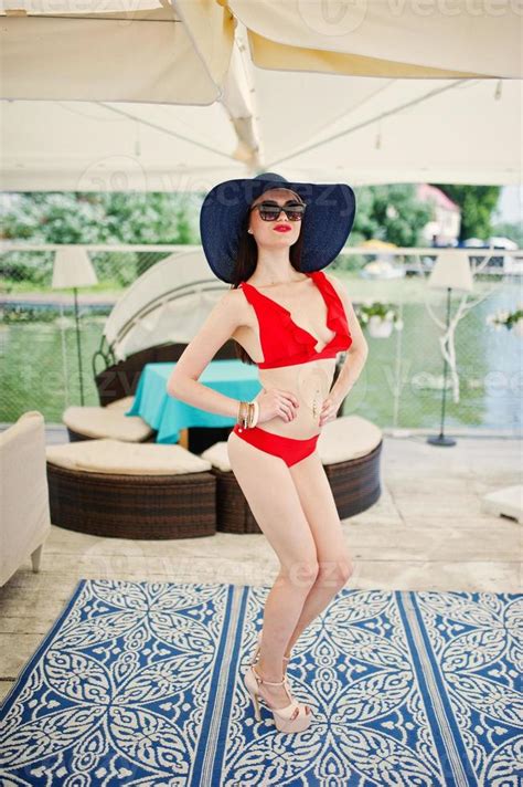 Impresionante Mujer Joven En Bikini Rojo Posando Con Sombrero Y Gafas De Sol En El Muelle Junto