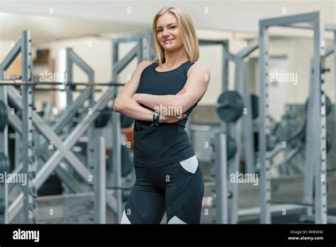 Portrait Of Adult Blonde Fitness Woman Personal Trainer With Folded Hands In The Gym Beautiful