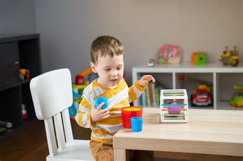 Um Menino Bonitinho De Dois Anos Senta Se Mesa Infantil E Brinca