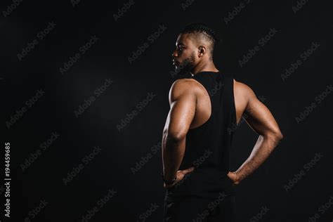 Back View Of Muscular Young African American Man Standing With Hands On