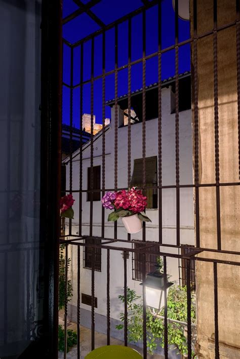 An Iron Gate With Flowers In The Window