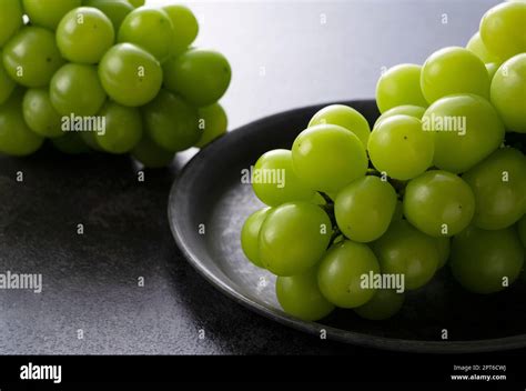 Shine Muscat Placed On An Iron Plate Against A Black Background White