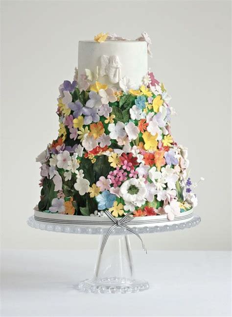 A Multi Tiered Wedding Cake Covered In Flowers