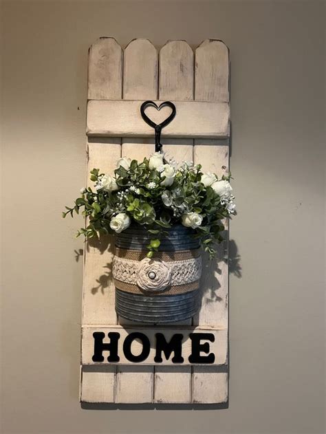 A Potted Plant Hanging On A Wall With The Word Home