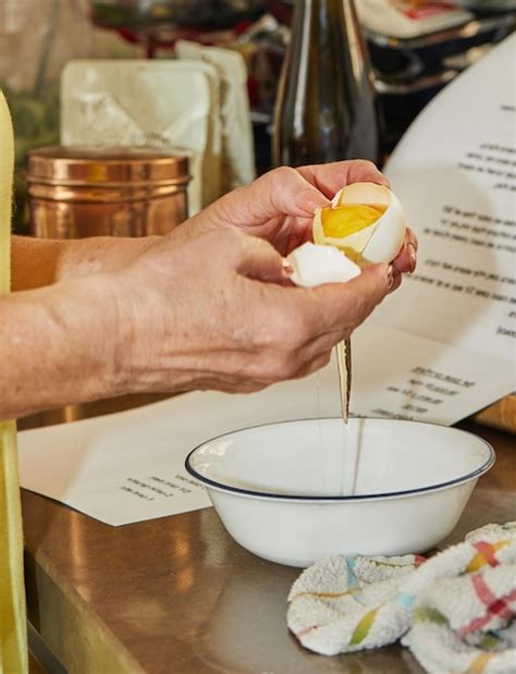 La Mujer Separa La Clara De La Yema De Un Huevo En La Cocina De Su Casa