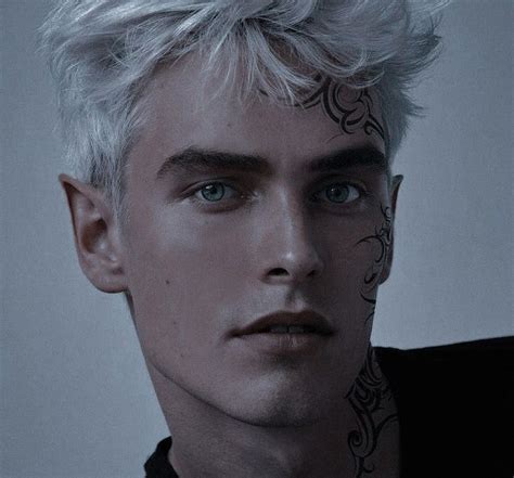 A Man With White Hair And Tattoos On His Face