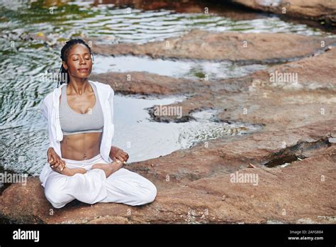 Serene Young Fit Black Woman Sitting In Lotus Position By The River