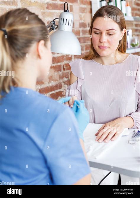 Manicurist Doing Manicure By Nail To Girl In Modern Beauty Salon Stock