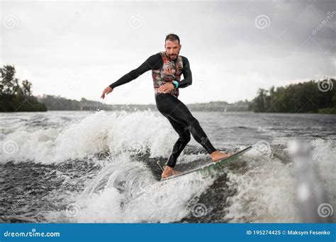 Man in Swimsuit Surfing on Surfboard Trails Behind Boat. Stock Image ...