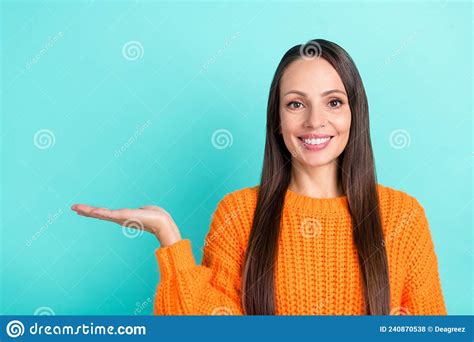 Photo Of Optimistic Young Brunette Lady Hold Empty Space Wear Orange