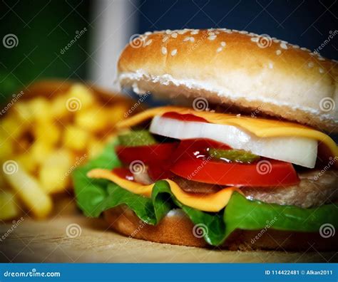 Hamburger E Batatas Fritas Em Uma Tabela De Madeira Imagem De Stock